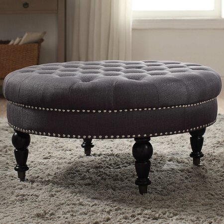 Small round low foot stool upholstered upholstered cushion material on 4 feet of wood.