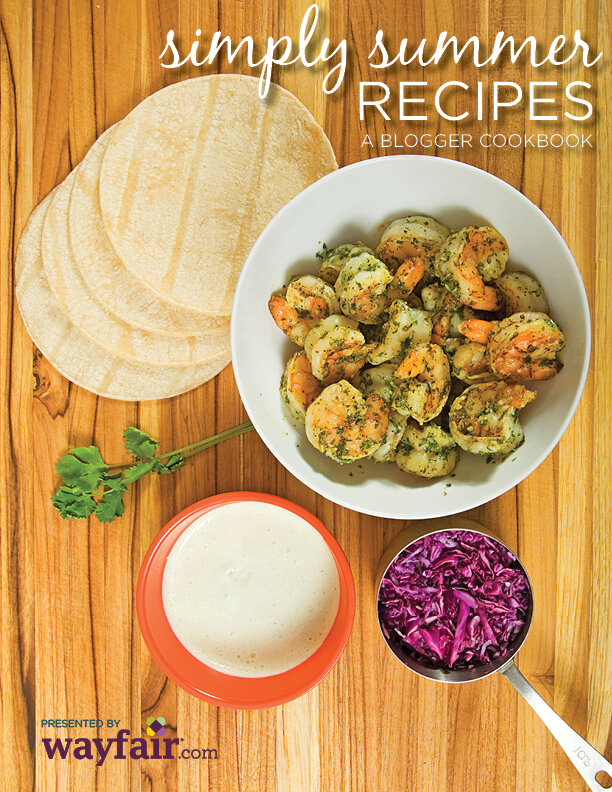 Cookbook cover featuring cooked shrimp in a bowl on a wood table, alongside tortillas, red cabbage, and parsley.