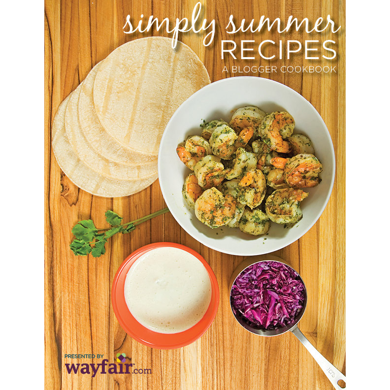 Cookbook cover featuring cooked shrimp in a bowl on a wood table, alongside tortillas, red cabbage, and parsley.